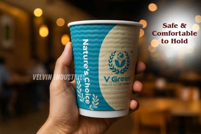 Hand holding a V Green ripple paper cup from Velvin Industries, showcasing eco-friendly, safe, and comfortable-to-hold design